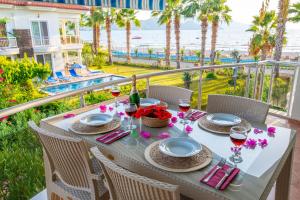 einen Tisch mit Gläsern Wein auf einem Balkon mit Meerblick in der Unterkunft Sunset Beach Club Aqualettings Poseidon 7 in Fethiye