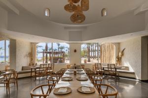 a dining room with tables and chairs and windows at MGM Wellness Clinic in Aswan