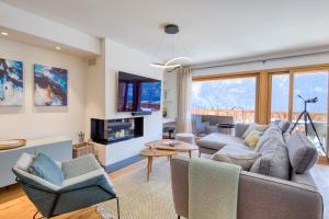 a living room with a couch and chairs at Apartment w pool and spa in Champéry