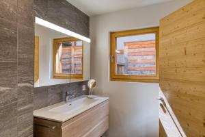 a bathroom with a sink and a mirror at Apartment w pool and spa in Champéry +21 photos