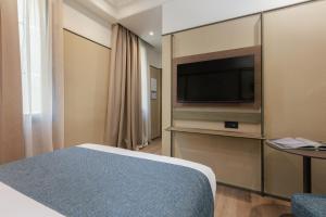 a hotel room with a bed and a flat screen tv at Hotel Medinaceli New reopening 2025 in Barcelona +49 photos