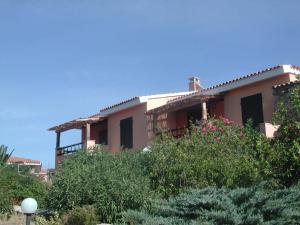 a house on top of a hill with flowers at Residence Spiaggia Bianca in Golfo Aranci