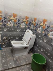 a bathroom with a toilet and flowers on the wall at Roshan Taj Homestay & Guest House Hostel in Agra