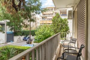 a balcony with chairs and trees and a building at Casa Riviera-Newly Renov 2Br Luxury Apt near Sea in Athens