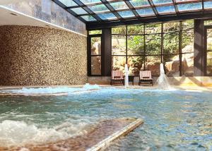 a person standing in a pool of water in a building at Grande Real Villa Itália Hotel & Spa in Cascais
