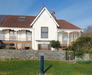 a large white house with a brick retaining wall at Velo Club Mumbles in Oystermouth