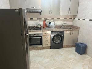 a kitchen with a refrigerator and a washing machine at Comfort Stay Oujda in Oujda