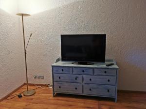 a tv on top of a dresser with a lamp at Vreni's Gästezimmer in Himmelried