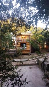 a small log cabin with a window in a yard at Guarda Garden Cabanas in Palhoça