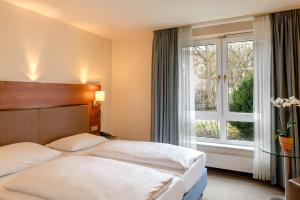 a hotel room with two beds and a window at Sunday Hotel München Airport Freising in Freising +39 photos