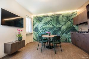 a kitchen with a table and chairs in front of a mural at Residence Alesi in Malcesine