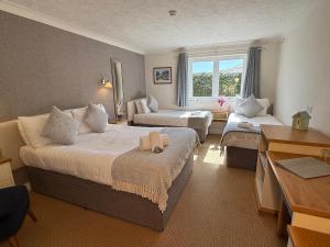 a hotel room with two beds and a couch at The River Haven Hotel in Rye
