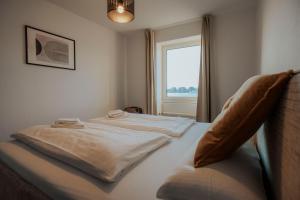 a bedroom with two beds and a window at Meerblick 8 - zwischen Haven und Meer in Wilhelmshaven