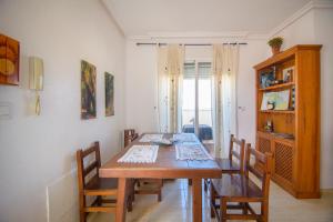a dining room with a wooden table and chairs at Natura Mediterranea Torremar atico 1 dorm naturista 430 in Playas de Vera