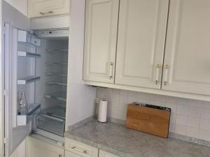 eine Küche mit weißen Schränken und einem leeren Kühlschrank in der Unterkunft FeWo Sulzbachtal, Nähe Europa-Park, Rulantica, Schwarzwald, Feldberg in Lahr + 83 Fotos