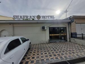 a white car parked in front of a garage at shafranhotel in Tashkent