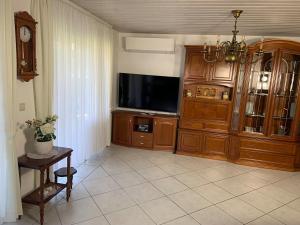 ein Wohnzimmer mit einem großen Entertainment-Center und einem TV in der Unterkunft FeWo Sulzbachtal, Nähe Europa-Park, Rulantica, Schwarzwald, Feldberg in Lahr