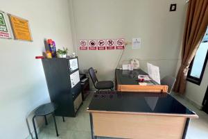 un bureau avec un bureau et des chaises dans la chambre dans l'établissement Gratia Guesthouse, à Jambi