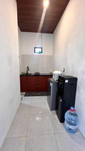 a kitchen with a sink and a refrigerator in a room at Villa kumudini's 2 in Diyeng +8 photos