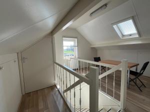a staircase in a house with a table and a window at B&K het hoenveld in Driel