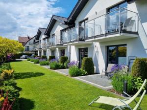 a house with a balcony and a lawn at Willa Klif in Rowy