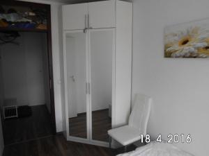 Cette chambre comprend une armoire et une chaise blanches. dans l'établissement Apartment Johanna, à Braunlage