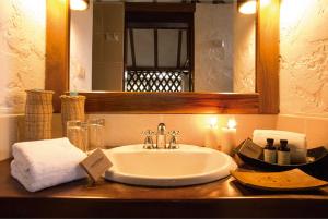 a bathroom counter with a sink and a mirror at Inkaterra Hacienda Concepcion in Puerto Maldonado