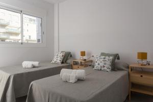 una habitación con dos camas y una ventana en AT Gregal I, en La Playa de la Torre de Piles