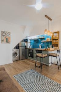 a kitchen with a table and chairs in a room at Chic Duplex in the heart of Setúbal in Setúbal