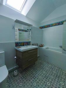 a bathroom with a sink and a tub and a toilet at Longère Kerhallec in Treffléan