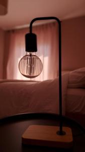a lamp sitting on a table next to a bed at Albero in Alexandroupoli