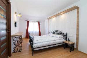 オクナ・シュガタグにあるPensiunea Marea Alpina, Maramuresの黒枠のベッド1台が備わるベッドルーム1室