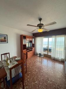 ein Wohnzimmer mit einem Esstisch und einem Deckenventilator in der Unterkunft Cullera-Apartment in Cullera