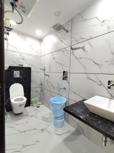a white bathroom with a toilet and a sink at Homlee-Virasat 3BHK Flat Central DEL-Lift-Parking in New Delhi
