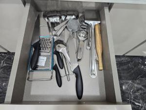a drawer filled with cooking utensils in a box at Homlee-Virasat 3BHK Flat Central DEL-Lift-Parking in New Delhi +11 photos