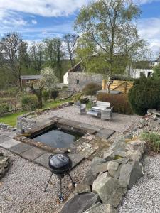 AIRDSIDE COTTAGE في قلعة دوغلاس: حديقة خلفية بها شواية وحفرة نار