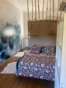 a bedroom with two beds and a painting on the wall at Chambre d'hôtes de la Savonnerie in Vénéjan