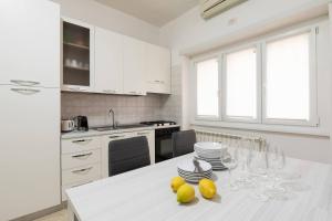 a white kitchen with a table with lemons on it at Garbatella Appartamento Moderno Relax e Comfort in Rome