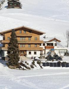 ein großes Holzgebäude im Schnee in der Unterkunft Appartement Hotel Garni Matthäuserhof in Gerlos