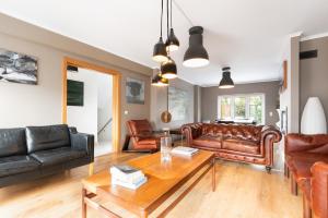a living room with leather furniture and a table at Exquisite Townhouse in Lisbon City Center- PRIVATE GARAGE & TERRACE in Lisbon