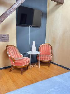 クルジュ・ナポカにあるCentral Luxury Apartamentのテレビ付きの客室で、椅子2脚とテーブル1台が備わります。