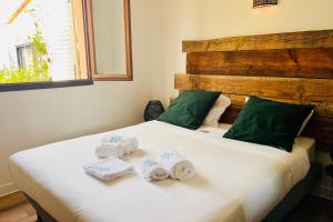 una camera da letto con un letto con asciugamani sopra di Sabali - Cottage Plage d'Argent at 100m - by TGB a Coti-Chiavari Altre 40 foto