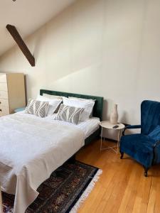 クルジュ・ナポカにあるCentral Luxury Apartamentのベッドルーム1室(ベッド1台、青い椅子付)