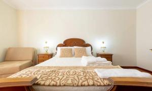a bedroom with a bed with a couch and a chair at Majestic Manor in Valença with private pool in Valença