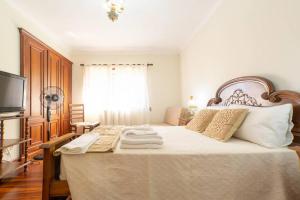 a bedroom with a large bed with towels on it at Majestic Manor in Valença with private pool in Valença