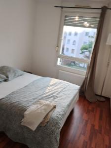 łóżko w pokoju z oknem i prześcieradłem w obiekcie Charmant appartement au centre w Strasburgu +17 zdjęć