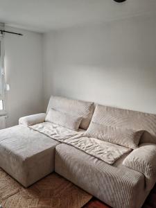 kanapa w pokoju z białą ścianą w obiekcie Charmant appartement au centre w Strasburgu