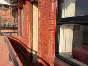 a brick building with a window on the side of it at Tehra Family Building in Kathmandu +4 photos