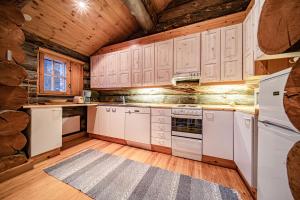 eine Küche mit weißen Geräten und Holzschränken in der Unterkunft Charming Cottage Levi in Levi + 11 Fotos