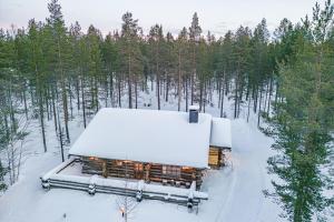 ein schneebedecktes Gebäude mit Bäumen im Hintergrund in der Unterkunft Charming Cottage Levi in Levi